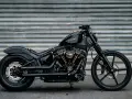 Czarny Harley-Davidson Dyna z błyszczącym lakierem i złotymi akcentami na silniku, gotowy do drogi.