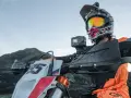 Motocyklista w kasku z kamerą na kierownicy, gotowy do jazdy po górskim terenie. Idealna kamera na kask motocyklowy do uchwycenia przygody.