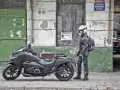 Motocyklista w kasku obok swojego futurystycznego Honda NM4 Vultus.