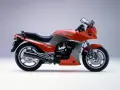 Pomarańczowy motocykl Kawasaki GPZ900R z szarymi akcentami, z lat 80., z owiewką i sportowym wyglądem.