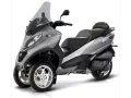 Srebrny Piaggio MP3 400 czy 500? Trójkołowy skuter z przyciemnianą szybą i sportowym designem.
