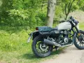Stojący na poboczu, w otoczeniu zieleni, motocykl Honda GB350 z sakwami gotowy na podróż.