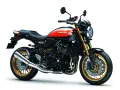 Stylowy motocykl Kawasaki Z900RS w kolorze czarnym z pomarańczowymi akcentami i złotymi felgami. Klasyka w nowoczesnym wydaniu.