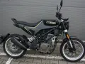 Czarny motocykl Husqvarna Svartpilen 401 z żółtymi akcentami, gotowy na miejskie przygody.