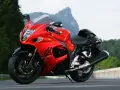 Czerwony motocykl Suzuki Hayabusa na drodze, z widokiem na góry. Poznaj jego suzuki hayabusa dane techniczne.