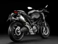 Czarny Ducati Monster 696 z podwójnym wydechem i sportowym wyglądem, gotowy do jazdy.