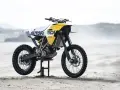 Żółto-biały motocykl customowy Autofabrica Type 17, bazujący na BMW G450X, stoi na plaży.