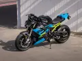 Potężny motocykl BMW S1000R w jaskrawych kolorach niebieskim i żółtym, gotowy do jazdy po torze.