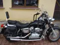 Czarny motocykl Honda Shadow 125, z sakwami i oparciem. Idealny na podróże, poznaj jego honda shadow 125 dane techniczne.