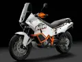 Biały motocykl KTM 990 Adventure z pomarańczowymi akcentami, gotowy na każdą przygodę.