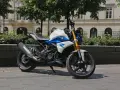 Biało-niebieski motocykl BMW G 310 R na tle kamienicy. Sprawdź jego dane techniczne!