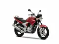 Czerwony motocykl Yamaha YBR 250 z czarnym siedzeniem i srebrnym wydechem, gotowy do jazdy po mieście.