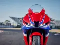 Czerwono-niebieski motocykl Honda CBR 600RR na torze wyścigowym. Poznaj honda cbr 600rr dane techniczne i poczuj moc!