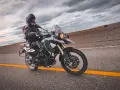 Motocyklista na BMW GS 800, mimo potencjalnych wad, cieszy się jazdą po pustej drodze.