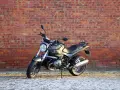 Szary motocykl BMW R1200R na tle ceglanej ściany. Poznaj jego dane techniczne i możliwości.