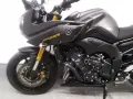 Ciemnoszary motocykl Yamaha FZ8 z żółtym napisem "FAZER" na owiewce. Widoczny silnik i przednie zawieszenie.