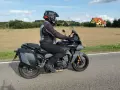 Motocyklista na Yamaha Tracer 900, z sakwami, w kasku, jedzie po drodze. Dane techniczne tego modelu są imponujące.