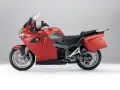 Czerwony motocykl turystyczny BMW K1300GT z kuframi, gotowy na długie podróże.