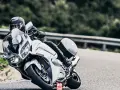 Motocyklista w białym Yamaha FJR 1300 na zakręcie drogi.
