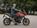 Mężczyzna na czerwonym motocyklu Triumph Tiger 1050. Poznaj jego dane techniczne i możliwości.