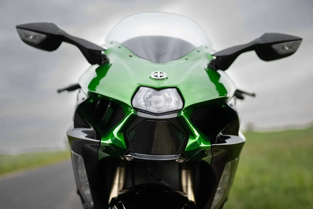 Przód zielono-czarnego motocykla Kawasaki Ninja H2 z błyszczącym logo i ostrymi liniami, gotowy do jazdy.
