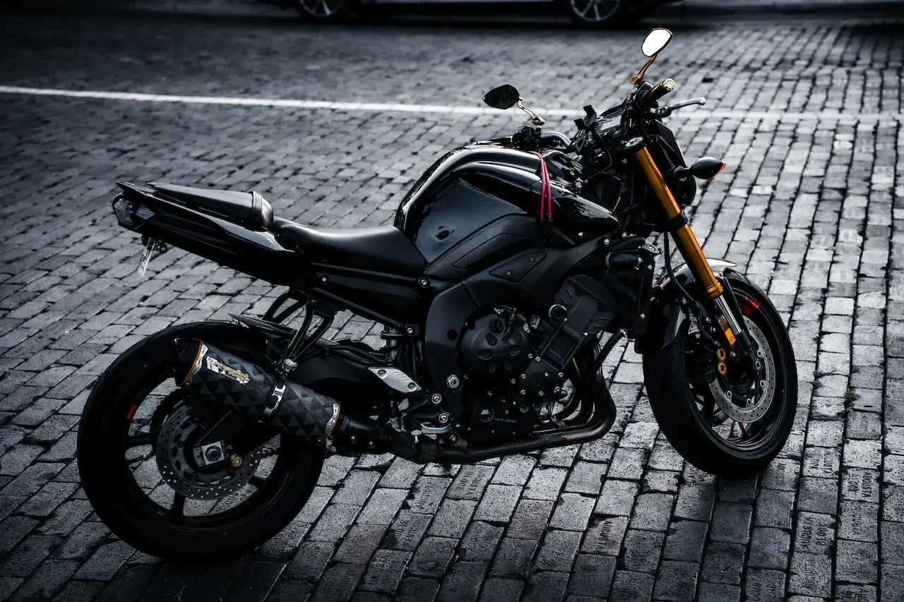 Czarny motocykl na bruku, idealny na giełda motocykli używanych Niemcy. Gotowy do jazdy po niemieckich drogach.