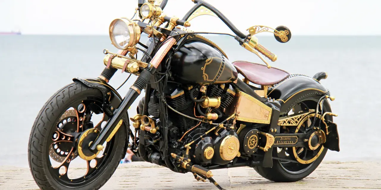 Niestandardowy Yamaha Wild Star 1600 w stylu steampunk, z bogactwem złotych detali i mosiężnych elementów, prezentuje się imponująco nad morzem.