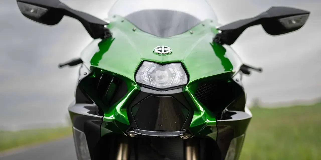 Przód zielono-czarnego motocykla Kawasaki Ninja H2 z błyszczącym logo i ostrymi liniami, gotowy do jazdy.