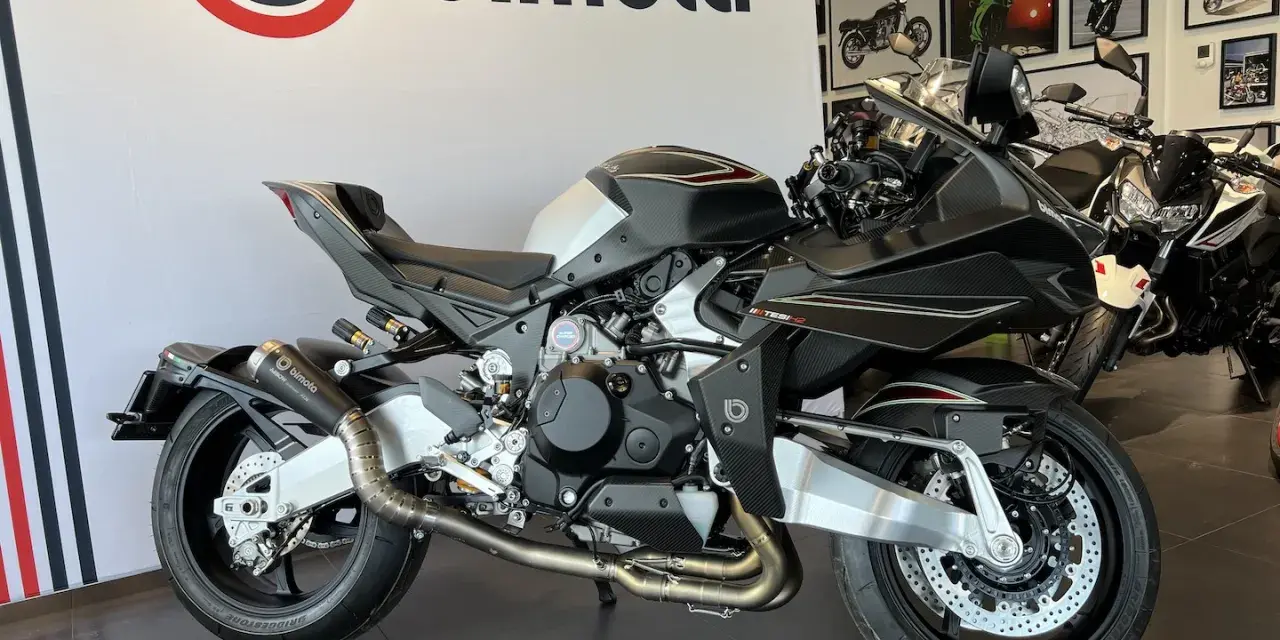 Czarny motocykl Bimota Tesi H2 z włókna węglowego, z podwójnym wydechem i sportowym zawieszeniem, gotowy do jazdy.