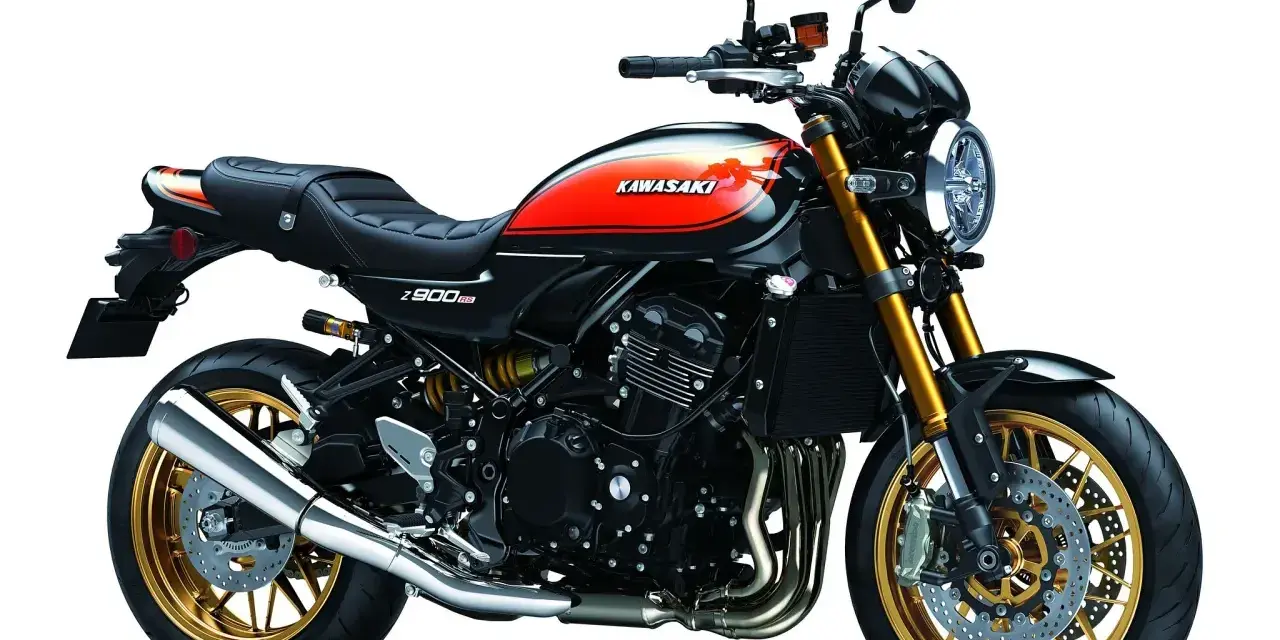 Stylowy motocykl Kawasaki Z900RS w kolorze czarnym z pomarańczowymi akcentami i złotymi felgami. Klasyka w nowoczesnym wydaniu.
