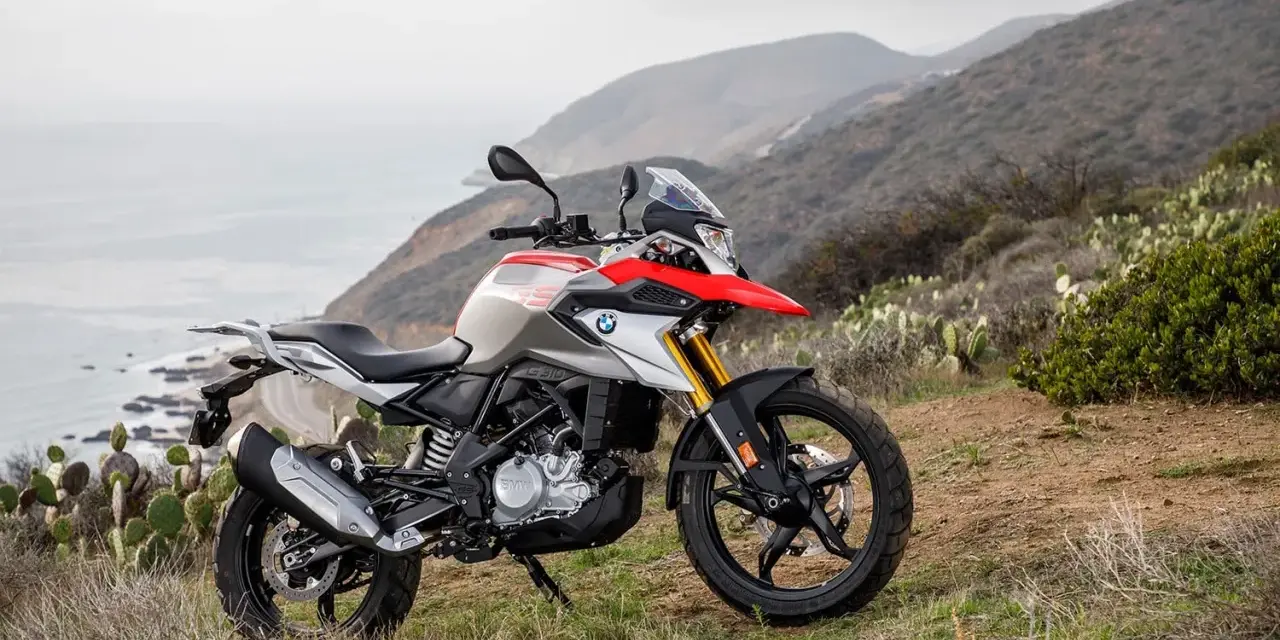BMW G 310 GS na tle górskiego krajobrazu z widokiem na ocean. Poznaj jego dane techniczne i możliwości terenowe.