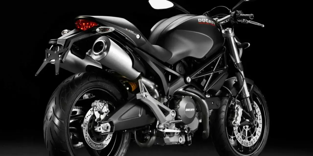 Czarny Ducati Monster 696 z podwójnym wydechem i sportowym wyglądem, gotowy do jazdy.