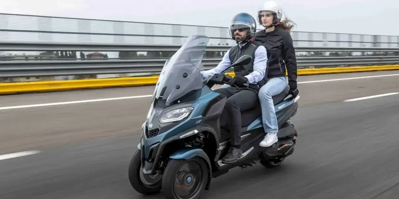 Para jadąca na Piaggio MP3 500, testująca jego prędkość maksymalną na torze wyścigowym.
