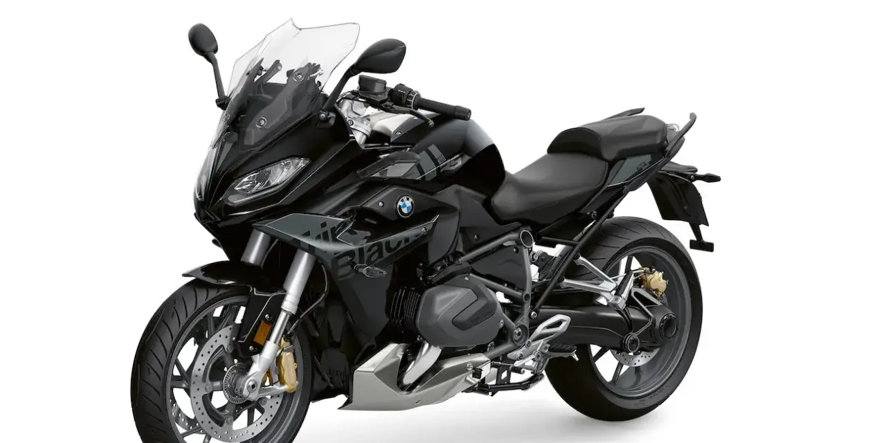 Czarny motocykl BMW 1250 RS z przyciemnianą szybą i sportowym wyglądem, gotowy na każdą podróż.