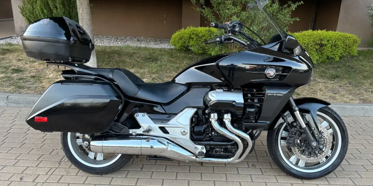 Czarny motocykl Honda CTX 1300 z kufrem centralnym i bocznymi, gotowy na podróż.