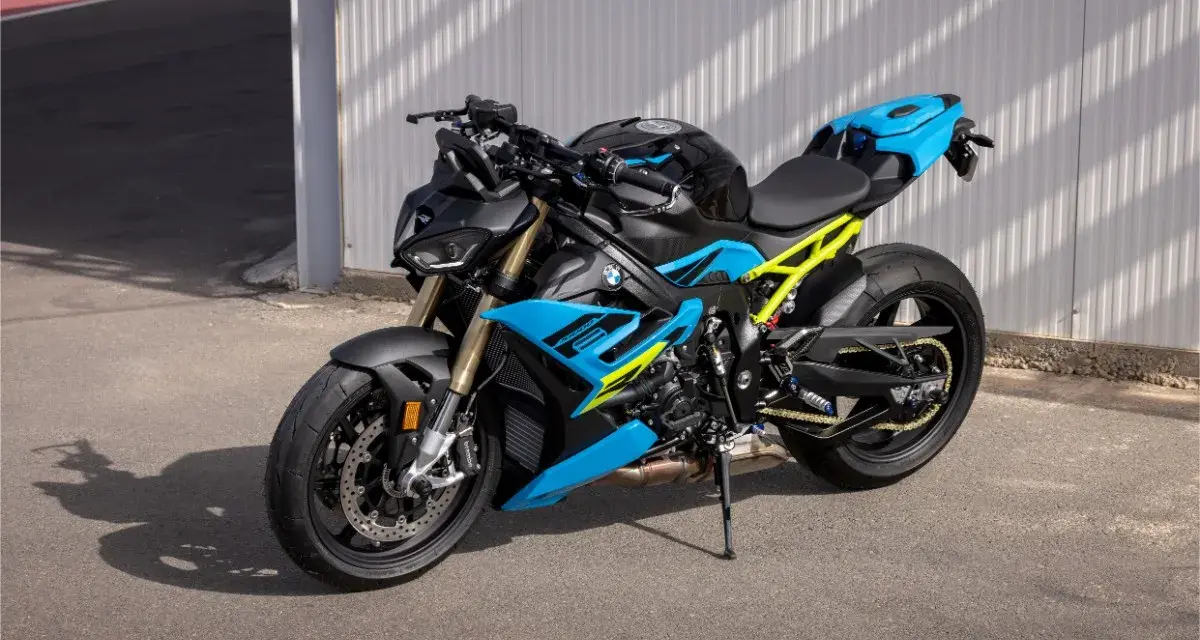 Potężny motocykl BMW S1000R w jaskrawych kolorach niebieskim i żółtym, gotowy do jazdy po torze.