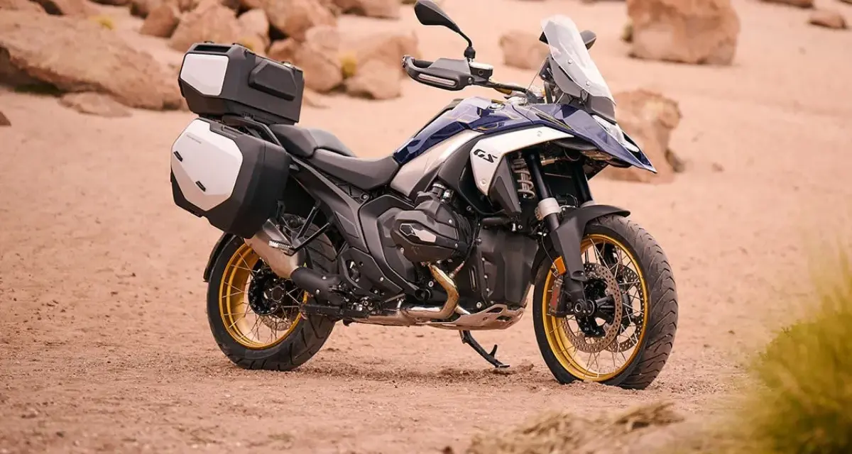 Nowy motocykl BMW R1300GS z kuframi, gotowy na przygodę po pustynnych terenach.