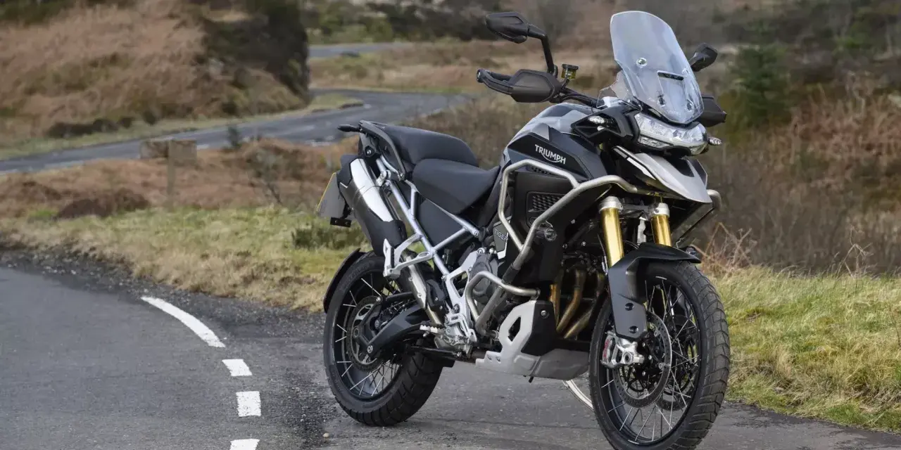Czarny motocykl Triumph Tiger 1200 na tle krajobrazu. Poznaj jego imponujące triumph tiger 1200 dane techniczne.
