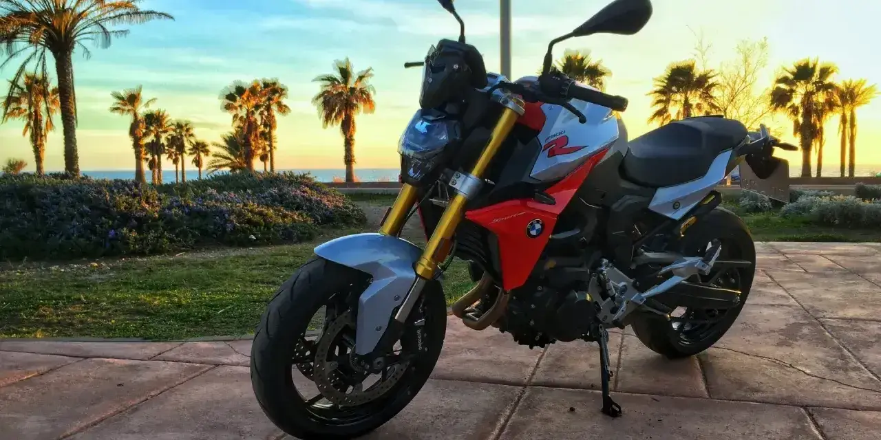 BMW F900XR na tle palem i zachodzącego słońca. Idealny motocykl na wakacyjne podróże.