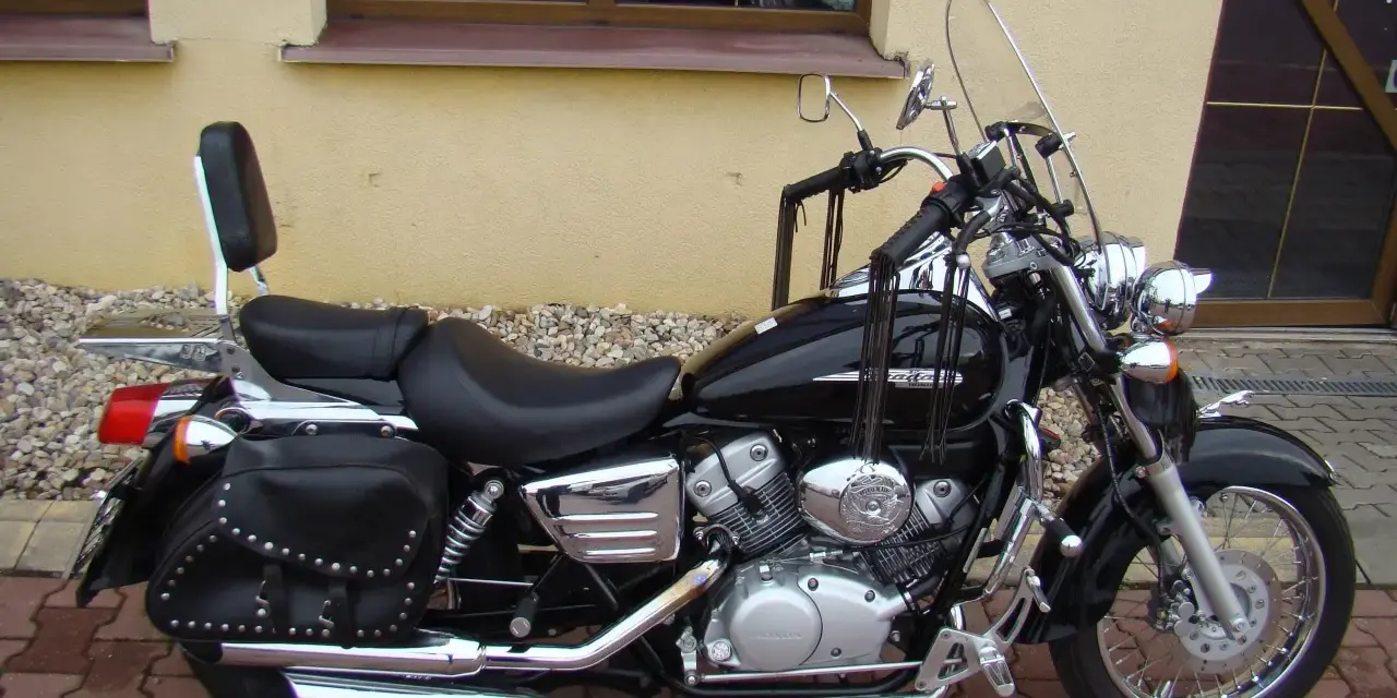 Czarny motocykl Honda Shadow 125, z sakwami i oparciem. Idealny na podróże, poznaj jego honda shadow 125 dane techniczne.
