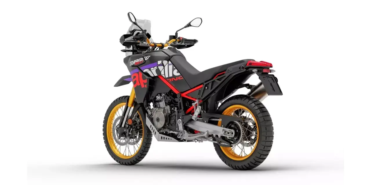 Czarny motocykl Aprilia Tuareg 660 z czerwonymi i fioletowymi akcentami, złote felgi. Dane techniczne tego modelu są imponujące.