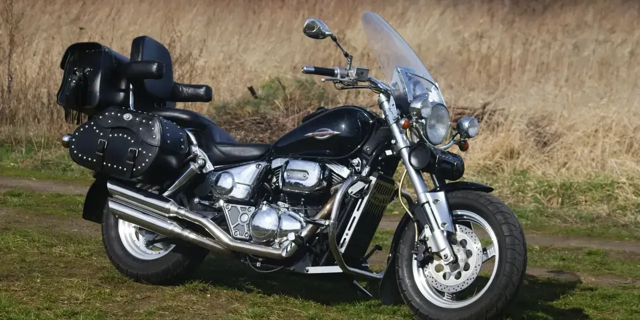 Czarny Suzuki Marauder z sakwami i oparciem, gotowy na podróż przez jesienne krajobrazy.