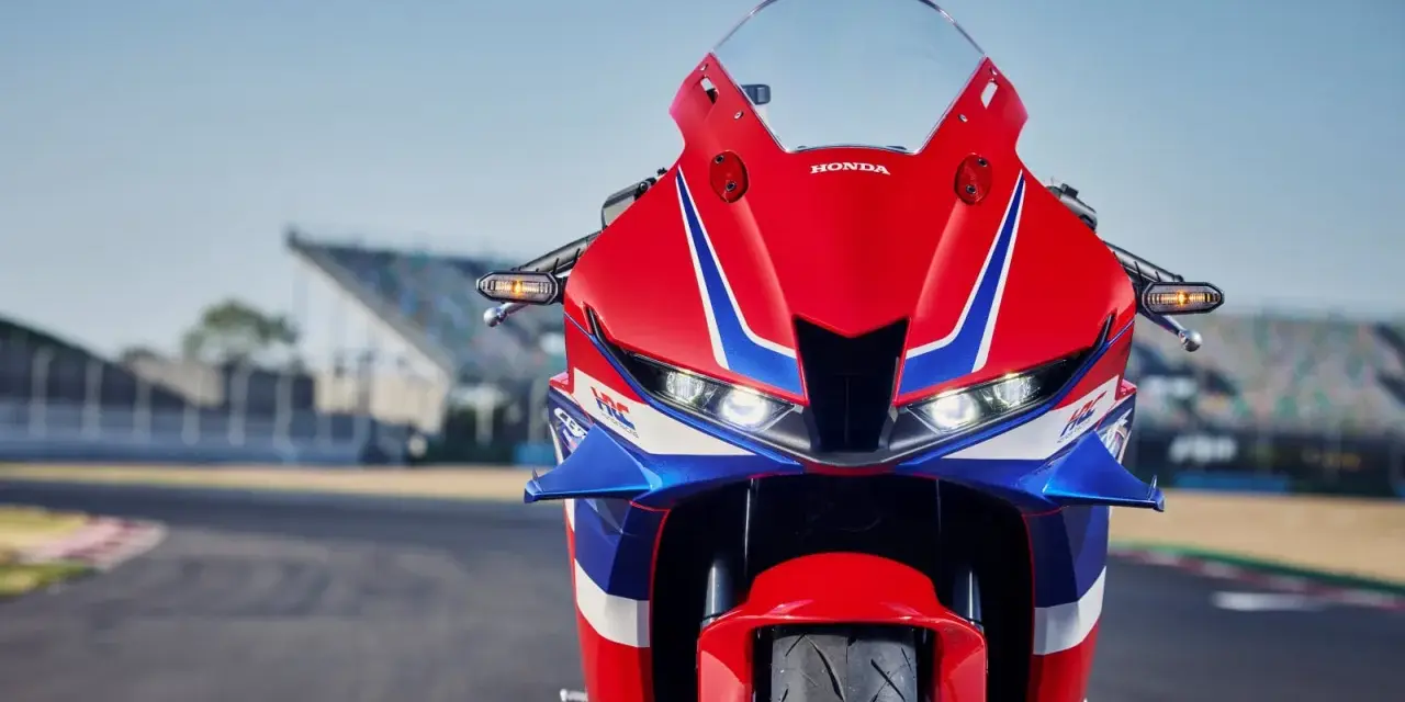 Czerwono-niebieski motocykl Honda CBR 600RR na torze wyścigowym. Poznaj honda cbr 600rr dane techniczne i poczuj moc!