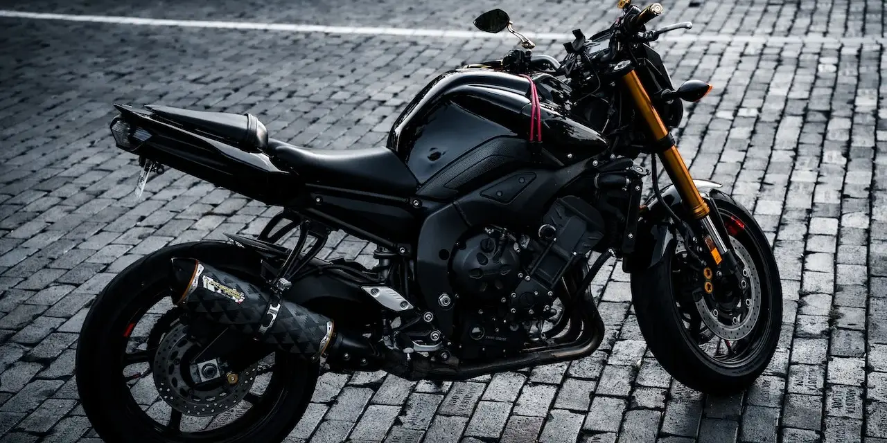 Czarny motocykl na bruku, idealny na giełda motocykli używanych Niemcy. Gotowy do jazdy po niemieckich drogach.