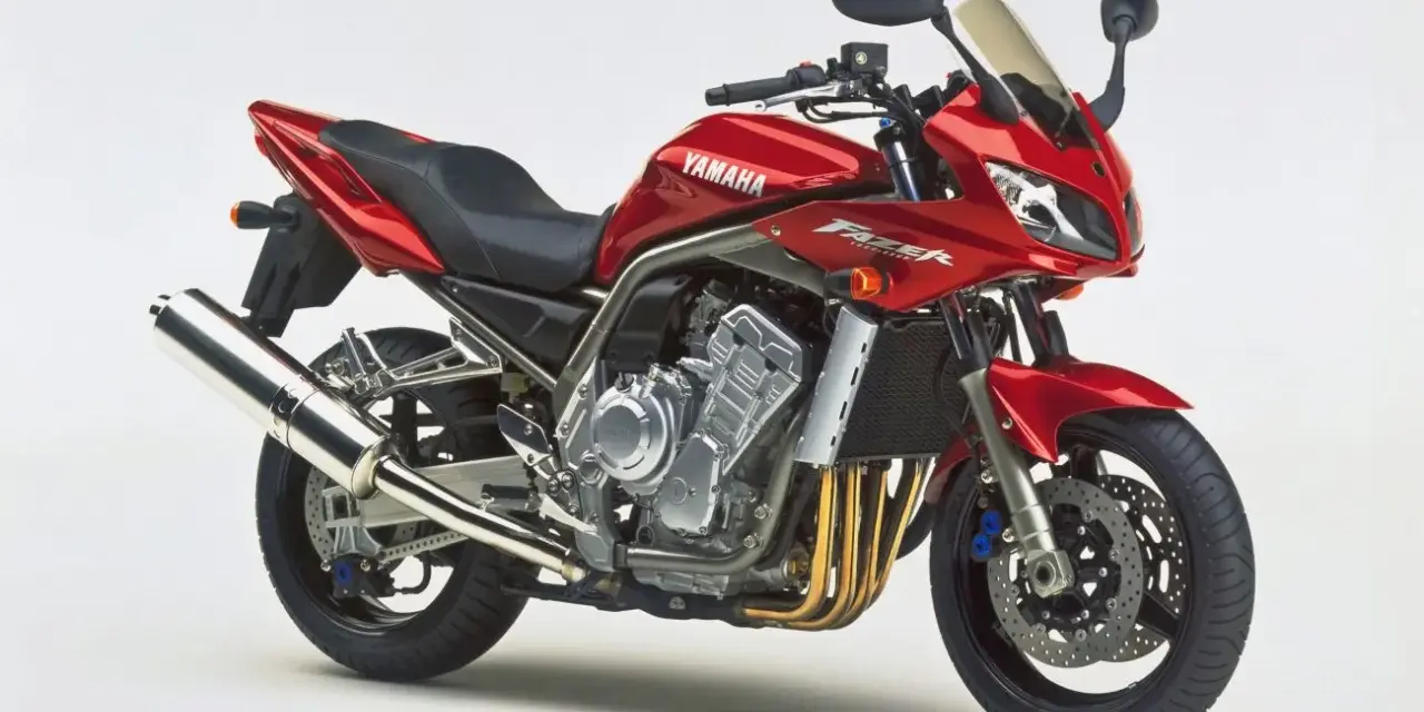 Czerwony motocykl Yamaha Fazer 1000, z widocznym silnikiem i wydechem. Choć piękny, warto pamiętać o jego potencjalnych wadach.