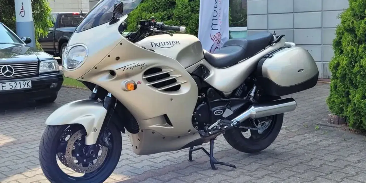 Złoty motocykl Triumph Trophy 1200, gotowy do podróży. Dane techniczne tego klasyka są imponujące.