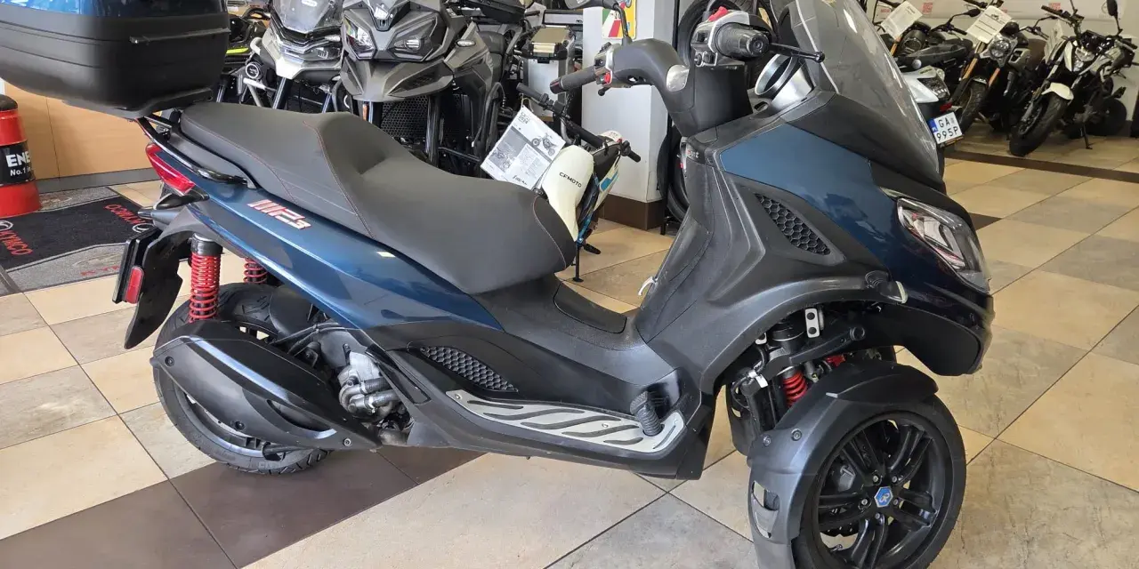 Trójkołowy skuter Piaggio MP3 300 w salonie. Sprawdź piaggio mp3 300 dane techniczne, by poznać jego możliwości.