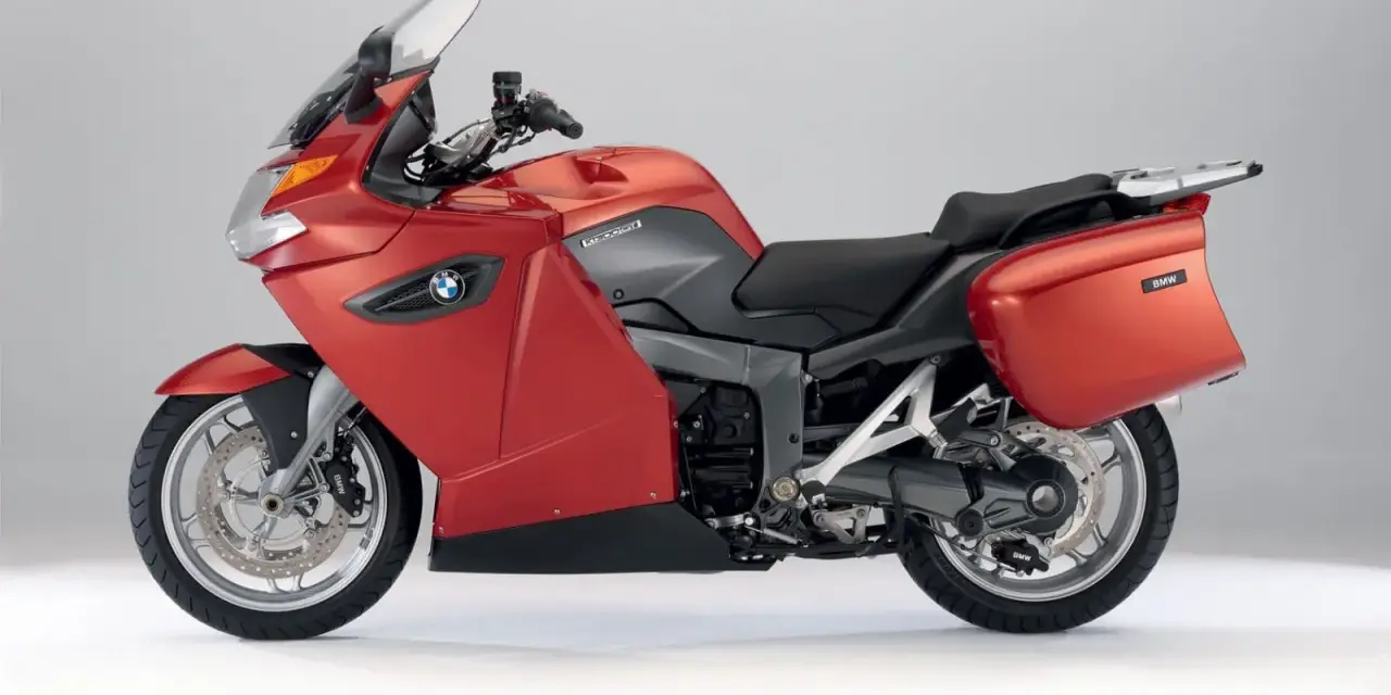Czerwony motocykl turystyczny BMW K1300GT z kuframi, gotowy na długie podróże.