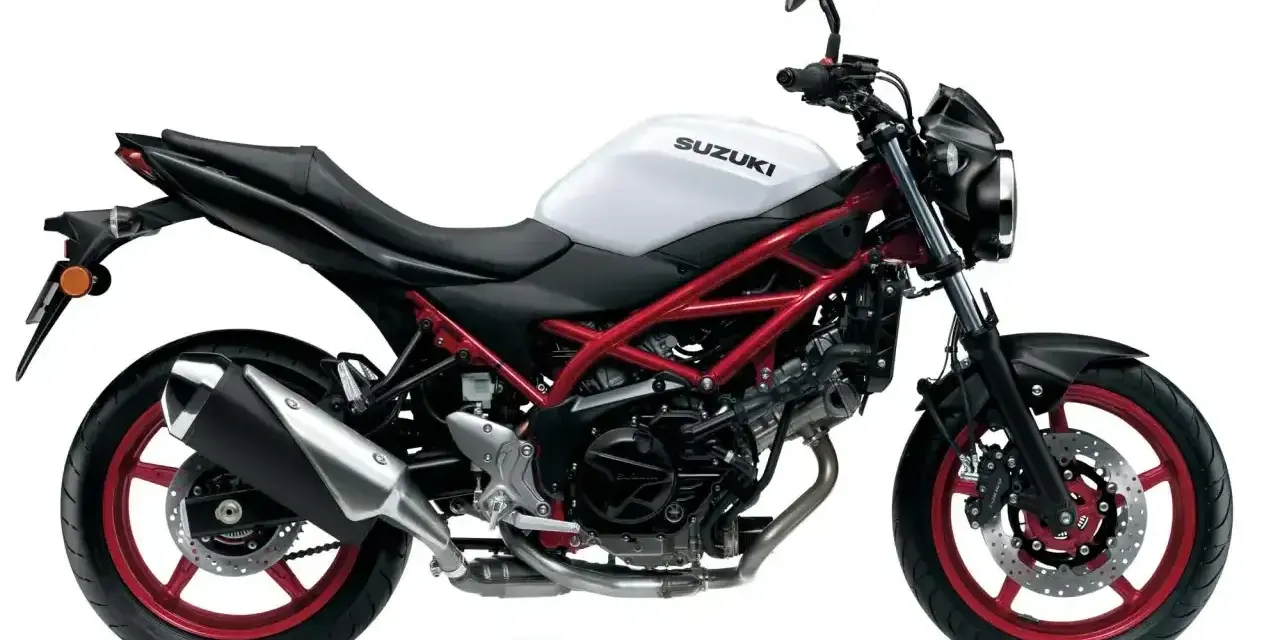 Biały motocykl Suzuki SV 650 z czerwonym stelażem, idealny do miasta. Poznaj suzuki sv 650 dane techniczne.
