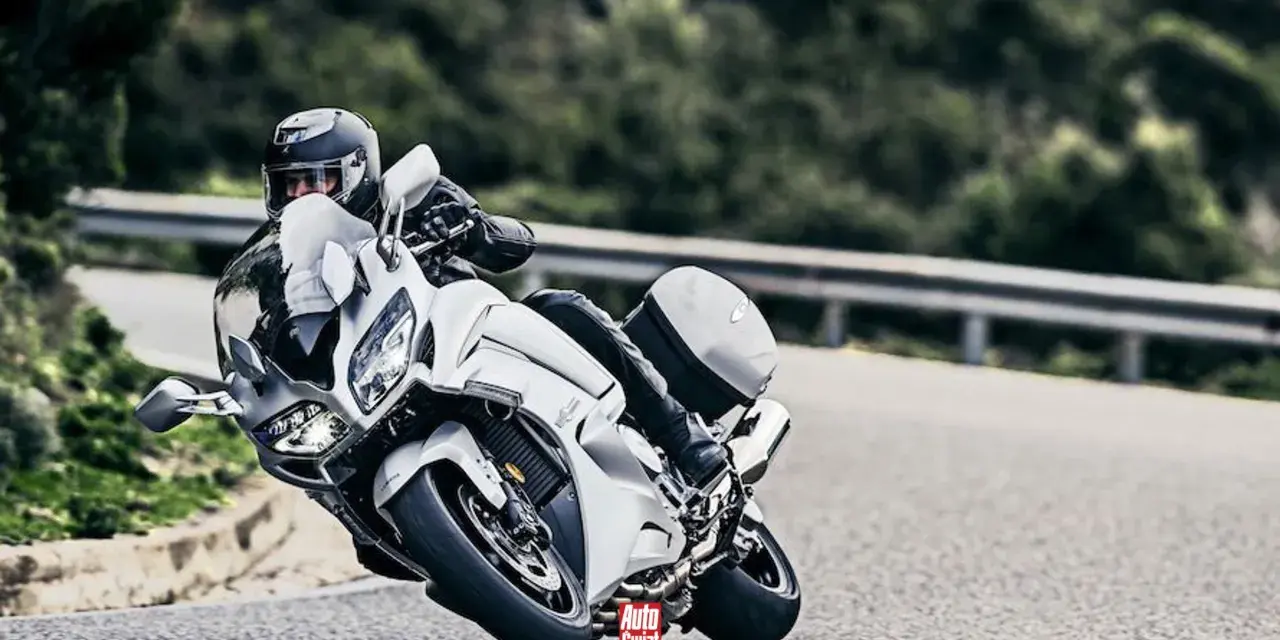 Motocyklista w białym Yamaha FJR 1300 na zakręcie drogi.